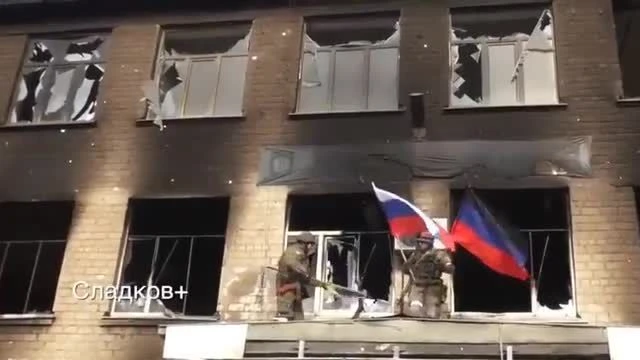 Mariupol: Bandiera russa e bandiera della DPR sventolano sul quartier generale nazista di Azov.